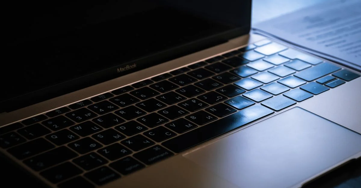 Une image en gros plan mettant en valeur un clavier d'ordinateur portable avec un éclairage ambiant mettant en évidence les touches.
