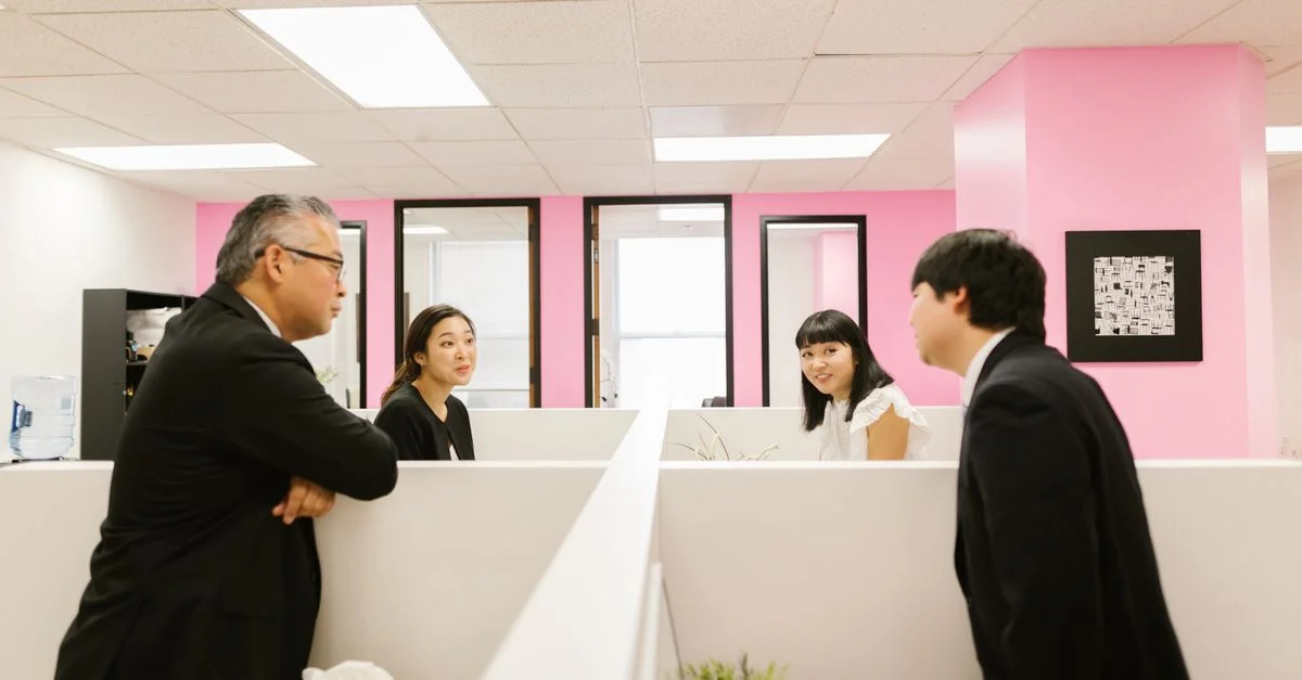 Un groupe de collègues asiatiques engagés dans une discussion animée dans un cadre de bureau moderne.