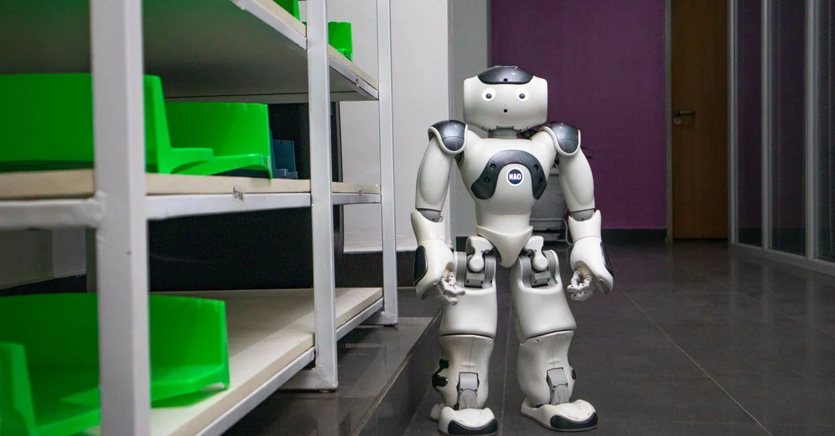 Un robot humanoïde debout dans un couloir moderne avec des étagères, représentant la technologie futuriste.