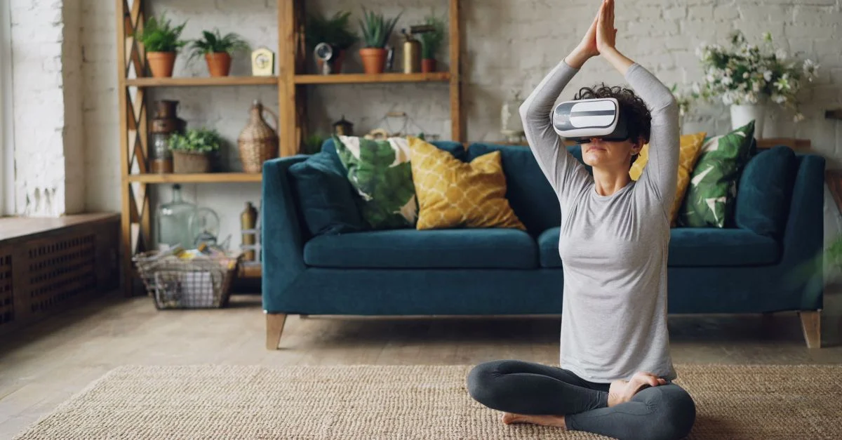 Femme pratiquant le yoga avec un casque VR dans un cadre domestique confortable.
