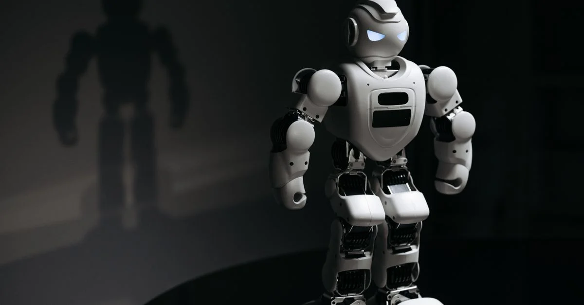 Jouet robot blanc projetant une ombre dans un studio sombre, mettant en avant l'intelligence artificielle.